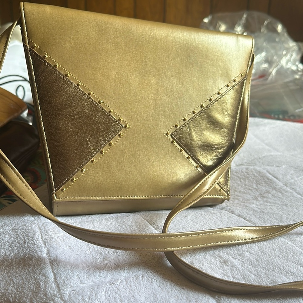 Women’s gold crossbody with snap closure.